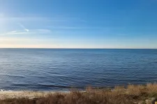 Blue horizon and ocean with a beach. Photo.